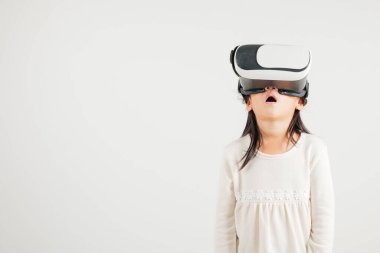 Gülümseyen genç kız özgüveni heyecan verici sanal gerçeklik deneyimi sırasında VR kulaklık takıyor izole edilmiş beyaz arka plan, Asyalı mutlu portre anaokulu çocuğu video oyunu stüdyosu çekimi yapıyor