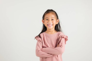 Asyalı mutlu portre, gülümseyen, kendine güveni yüksek, beyaz arka plan ve fotokopi alanında izole edilmiş, çocuk yuvası, çocuk yuvası, yaşam tarzı katlanmış, kolları kavuşturulmuş bir kız çocuğu.
