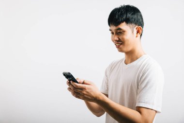 Sosyal medya stüdyosu için cep telefonu kullanan Asyalı gülümseyen genç adam, izole edilmiş beyaz arka plan, akıllı telefondan mesaj yazan mutlu yaşam tarzı erkekler, online mobil uygulama