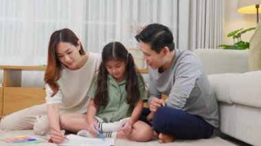 Gülümseyen baba, anne ve kız evdeki kağıt üzerine resim çiziyorlar, Asyalı aile oturma odasında kızıyla birlikte resim yapıyor, mutlu aile aktiviteleri öğreniyor, resim çizmeyi öğreniyor.