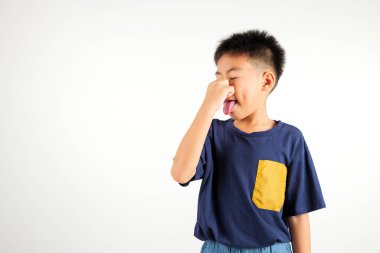 Asyalı küçük mutsuz bir çocuk parmaklarıyla burnu sıkan ne iğrenç bir koku. Çocuklar için kötü bir koku durumu var. Stüdyo çekimleri beyaz arka planda, sağlık hizmetlerinde izole edilmiş.