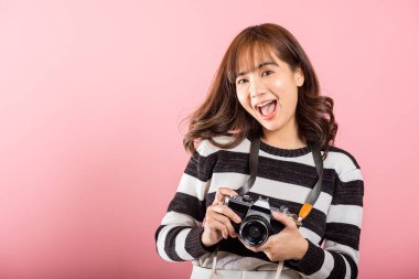 Çekici, enerjik, mutlu bir Asyalı portresi. Güzel, tatlı, genç bir kadın. Elinde eski model bir fotoğraf makinesiyle heyecanla gülümsüyor.