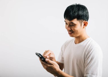 Sosyal medya stüdyosu için cep telefonu kullanan Asyalı gülümseyen genç adam, izole edilmiş beyaz arka plan, akıllı telefondan mesaj yazan mutlu yaşam tarzı erkekler, online mobil uygulama