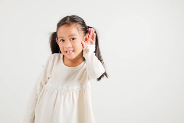 Asyalı genç bir çocuğun portresi, kulak misafiri olurken gülümsemesi kulak misafiri oluyor. Kulak üstüne kulak çekimleri, beyaz arka planda izole edilmiş fotokopi odası işitme hareketi, anaokulu kızı.