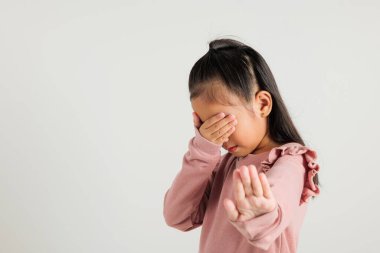 Anaokulu çocuğunun elini tut. Asyalı küçük kız şarkı söylemeyi kesiyor. Stüdyoda avucunun içi gibi şarkı söylüyor. Beyaz arka planda izole edilmiş, çocuk beş parmağını kaldırdı.