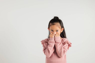 Asya portresi sevimli genç kız afallamış, ağzı korkuyla dolu el kameraları, stüdyo görüntüleri beyaz arka planda izole edilmiş Tayland anaokulu çocuğu korkmuş.