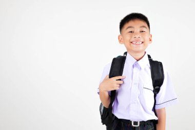 Gülümseyen Asyalı küçük çocuk okul çantası ile poz veriyor izole edilmiş beyaz arka plan, mutlu sevimli çocuk okul üniforması ve sırt çantası giyiyor, okula geri dönüyor.