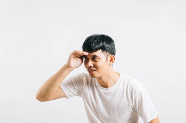 Uzaklardan bir şey görmeye çalışan Asyalı gülümseyen genç adam avucunun içinde izole edilmiş beyaz arka plan, mutlu yaşam tarzı erkekler insan elini taşır ve mesafe arar.