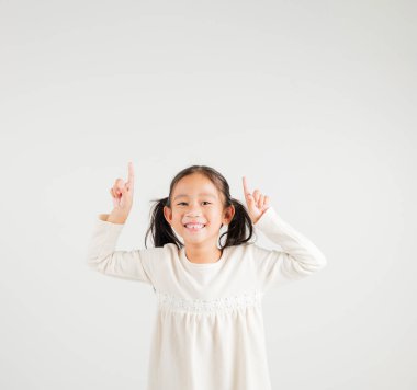 Asyalı mutlu bir portre. Sevimli bir kız el hareketi yapıp ürününü sunuyor. Stüdyo resmi, beyaz arka planda izole edilmiş, kreş çocuğu kadın gülümsemesi.