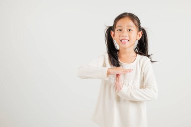 Yakından bakınca gülümseyen genç kız el hareketi yapıyor. Stüdyo çekimleri beyaz arka planda. Anaokulu çocuğu el işaretini kırıyor, zamanı fotokopi ile durduruyor.