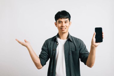 Portre Asyalı gülümseyen genç adam cep telefonu tutuyor ve elini boş bir uzay stüdyosuna açıyor izole edilmiş beyaz bir arka plan, mutlu heyecanlı yaşam tarzı erkekler ellerinde akıllı telefon ile bir şeyler sunuyorlar.