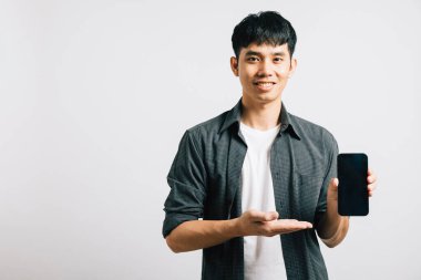 Asyalı portre gülümseyen genç adam cep telefonu boş ekranını ve el açık stüdyo çekimini izole edilmiş beyaz arka plan, mutlu yaşam tarzı erkekler akıllı telefon sunumunu avuç içi ve ekranda yapıyor.