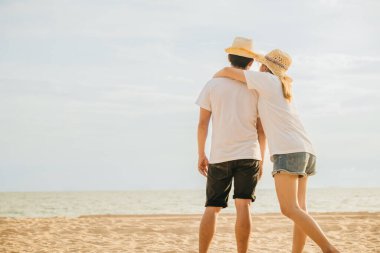 Sahilde yan yana duran Asyalı çift, sevgilisini kucaklayan mutlu genç kadın, deniz kenarında balayı tatili geçmişi, aşık çift, denizde dinleniyor.