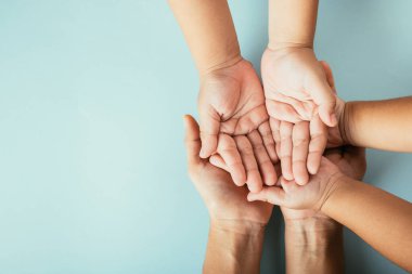 Soyutlanmış arka planda aile bireylerinin yakın çekim görüntüsü. Ebeveynler ve çocuklar Aile ve Ebeveynler Günü 'nde destek ve sevgiyi simgeleyen boş bir alan tutuyorlar..