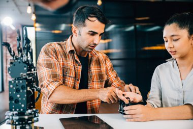 Sınıf ayarlama öğretmeni, öğrencilerin tasarım ve teknoloji dersi için robot kolu kullanmalarına yardımcı oluyor. Bilim eğitiminde takım çalışması yeniliklerini ve kodlama becerilerini teşvik etmek. Robot el. Yenilik teknolojisi