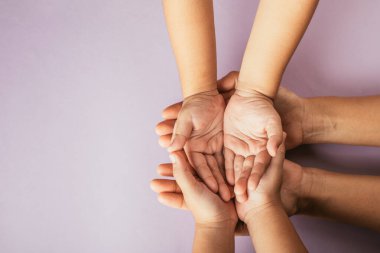 Ebeveynler ve çocuklar boş elleri tutuyorlar. Üst görünüm renk arkaplanından izole edilmiş. Aile Günü 'nü kucaklamak beraberlik desteği ve mirası sembolize eder.