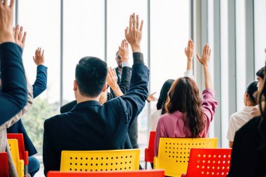 Strateji oturumu sırasında iş adamları toplantı ve seminer için toplantı odasında toplandılar. Kaldırılan eller, meslektaşlar ve çalışanlar arasında aktif bir ilişki ve takım çalışmasına işaret ediyor.