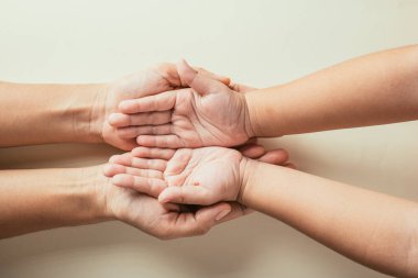 Ebeveynler ve çocuklar boş elleri tutuyorlar. Üst görünüm renk arkaplanından izole edilmiş. Aile Günü 'nü sembolize ediyor. Birliktelik ve kuşak desteği ile birleşiyor..