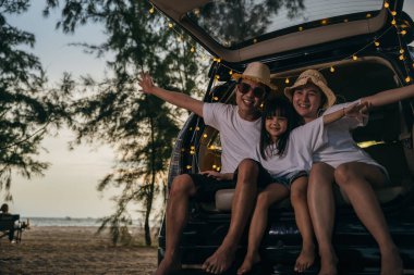 Asyalı bir aile gün batımında arabalarıyla sahilde oturuyor. Tatillerde ve tatillerde kendilerini tuhaf hissediyorlar. Baba, anne-kız iyi hafta sonları tatilleri. Plajda iyi eğlenceler. Yaz tatili kamp gezisi