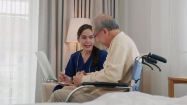Hasta dosyasını taşıyan Asyalı kadın doktor tekerlekli sandalyede oturan yaşlı adama, sağlık hizmetlerine ve tıbbi tedaviye ilişkin sonuçları anlatırken hasta dosyasını tutuyor.