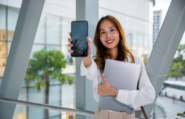 Professional woman uses her laptop and cellphone in an airport, multitasking with ease and efficiency, while staying connected and organized. making use of digital tools and connectivity clipart