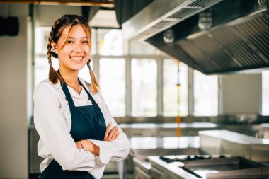 Modern bir mutfak restoranında kendine güvenen bir kadın şefin portresi. Mesleki uzmanlık alanında başarılı. Lezzetli yemekler sunuyor..