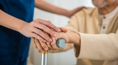 Doktorun ya da hemşirenin elleri sıhhiye kontrolünde baston kullanan yaşlı bir adamın ya da baston kullanan yaşlı bir adamın elini tutarken ya da yaşlılara yardım ederken, doktor avuç içi bakımı, sağlık hizmetleri ve tıbbi bakım hizmetleri...