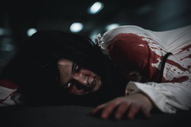 The girl was hit by a car and lying died on the road. full of blood left unattended, Horror bloodthirsty woman ghost horror she death and scary at night in tunnel, Happy halloween day concept