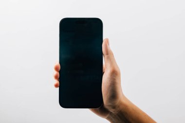 Siyah akıllı telefonun boş ekran görüntüsünü tutan bir adam, beyaz arka planda izole edilmiş siyah bir cep telefonunu tutan bir el, web sitesi tasarım uygulaması