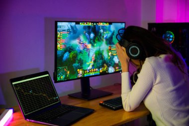 Oyun bitti, kaybettin. Evde bilgisayar başında oyun kulaklığı takan Asyalı kızgın oyuncu, NFT oyununun kaybedilmesinden hayal kırıklığına uğradı. Grafik yatırımcılarını kaybetti, oyuncu mutsuz.