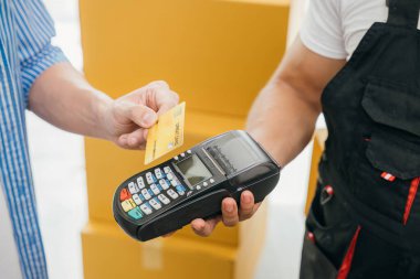 Aile, taşınma masraflarını kredi kartıyla karşılar. İşçi bir kutu tutuyor. Profesyonel nakliyeciler evlerin düzgün bir şekilde taşınmasını sağlarlar. Takım çalışması ve servis tasvir edildi. Taşınma Günü Kavramı