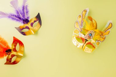 Happy Purim carnival accessories. Top view carnival mask for Mardi Gras celebration isolated on pastel green background, jewish holiday, Purim in Hebrew holiday