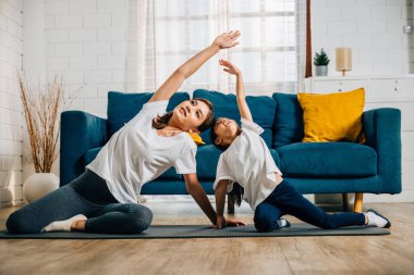 Evlerinin rahatlığında bir anne küçük kızını yaşam uyumu ve gücünü arttırmak için yoga konusunda eğitir. Aileler gülümser ve konsantre olurlar. Yürek ısıtan bir birliktelik anı yaratırlar..