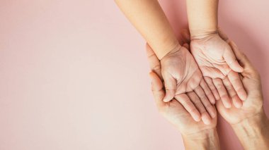 Aile gününü kutluyoruz, ailelerin ve çocukların el ele tutuşup renkli bir arkaplanda izole olmalarını izliyoruz. Metin için boşluk.