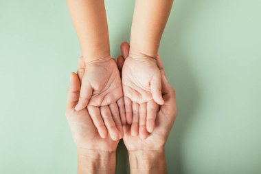 Aile Günü konsepti, ebeveyn ve çocuğun el ele tutuşması. Nesiller boyu birlikteliği ve desteği simgeliyor..