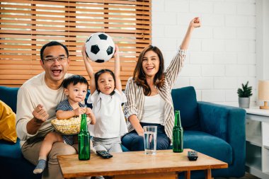 Bir aile ve kızları TV 'de bir futbol maçı izlemek için kanepede toplanıyor. Tezahüratları, kahkahaları ve beraberlikleri maçın neşesini yansıtıyor ve takımlarının zaferini kutluyorlar..