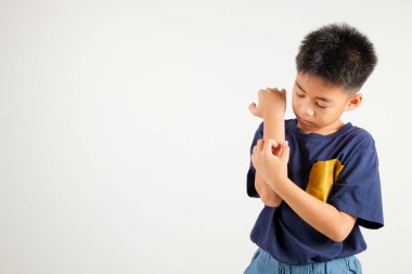 Asyalı küçük çocuk, beyaz arka planda izole edilmiş bir fotoğraf stüdyosundaki sivrisinek ısırığından kaşınan koluyla kaşınan Tayland ilköğretim dermatiti ve uyuz, alerji belirtileri, sıtma günü konsepti.