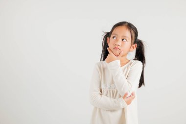 Asyalı bir kızın portresi derin düşüncelere dalmış, çenesi elinde, bir soru üzerinde kafa yoruyor. Stüdyo görüntüsü beyaz üzerine geniş kopya alanı ile izole edilmiş, anaokulu çocuğu derin düşüncelere dalmış ifade tasvir ediyor