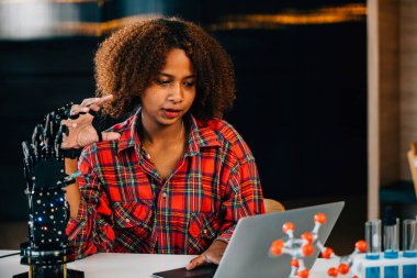 Neşeli bir genç dahi sınıfta insansı bir robot elle deneyler ve öğreniyor. Bilimsel yenilik ve beceri geliştirme teknolojisini benimsemek ve öğrenmedeki neşe.