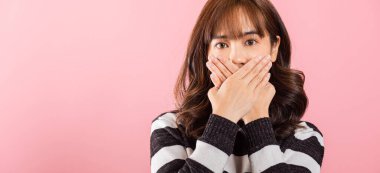 Asyalı mutlu bir portre gülümseyen güzel bir genç kadın elleriyle ağzını kapatıyordu ve pembe arka planda fotokopi çekiyordu.