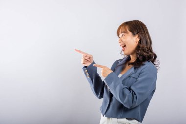 Heyecanlı bir kadın gülümseyerek kameraya iki silah hareketi yapar. İzole edilmiş beyaz arka plan, Mutlu Asyalı portresi. Güzel bir bayan seçilmiş olduğunu söylüyor.