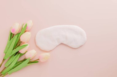 Dünya Uyku Günü şık bir maske ve pembe lalelerle. İyi uyuyun ve bu özel günde sağlık bilincini, bakımını ve korumasını vurgulayın. Üst görünüm, yağ yatağı