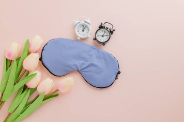 Dünya Uyku Günü 'nü şık bir uyku maskesi, çalar saat ve pembe arka planda pembe lalelerle kutlayın. Uyku farkındalığı ve sağlık hizmetlerinin teşvik edilmesi.