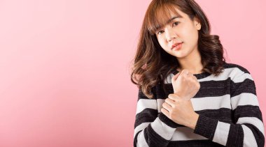 Asyalı güzel bir kadının portresi avuç içi ya da ellerde ağrıdan muzdarip ve acı dolu ellerine masaj yapan, stüdyo çekimi pembe arka planda izole edilmiş, sağlık sigortası artrit konsepti, bilek ağrısı...