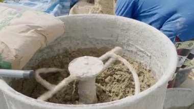 Dönen çimento karıştırıcısında gri havan ve kum, inşaat projeleri için dayanıklı betonun hazırlanmasını vurguluyor.