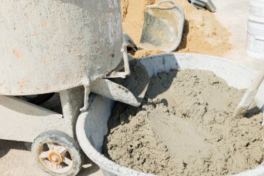 Çimento karıştırıcısı, gri havan ve bronz kumu karıştırarak düzgün bir inşaat kalitesinde karıştırıyor..