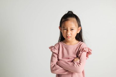 Asyalı bir portre genç kız kızgın ve kızgın duruyor. Öfkeli ve öfkeli bir şekilde yumruğunu kaldırıyor. Öfkesini izole edilmiş bir şekilde bağırıyor.