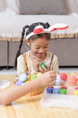 Paskalya zamanı. Mutlu bir anne ve çocuk Paskalya 'yı parlak renklerle yumurta boyayarak, boya fırçası kullanarak ve aileleriyle neşeli bir tatil geleneğinin tadını çıkararak kutluyor..