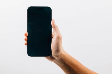 Siyah akıllı telefonun boş ekran görüntüsünü tutan bir adam, beyaz arka planda izole edilmiş siyah bir cep telefonunu tutan bir el, web sitesi tasarım uygulaması