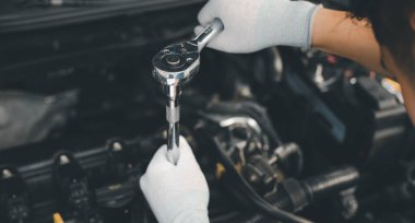 Service outdoor. Close up hands of auto mechanic man working on car engine using wrench to repair and maintenance, broken car care check and fixed the problem and services insurance